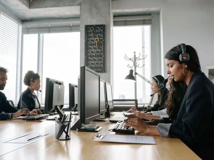 Support agents wearing headsets working at their desks